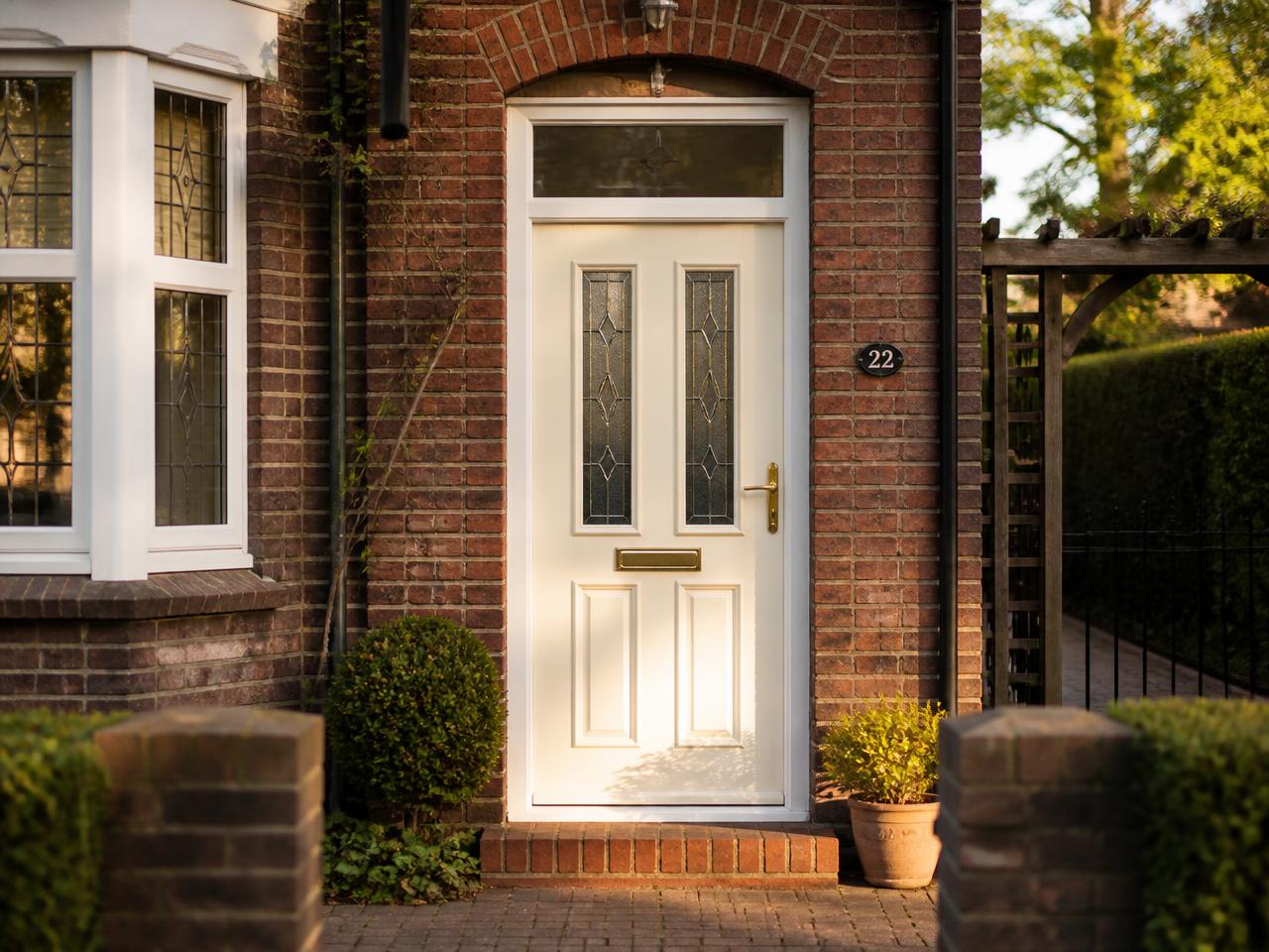 PVC front door in cream-white with a wood-look finish and glass panels